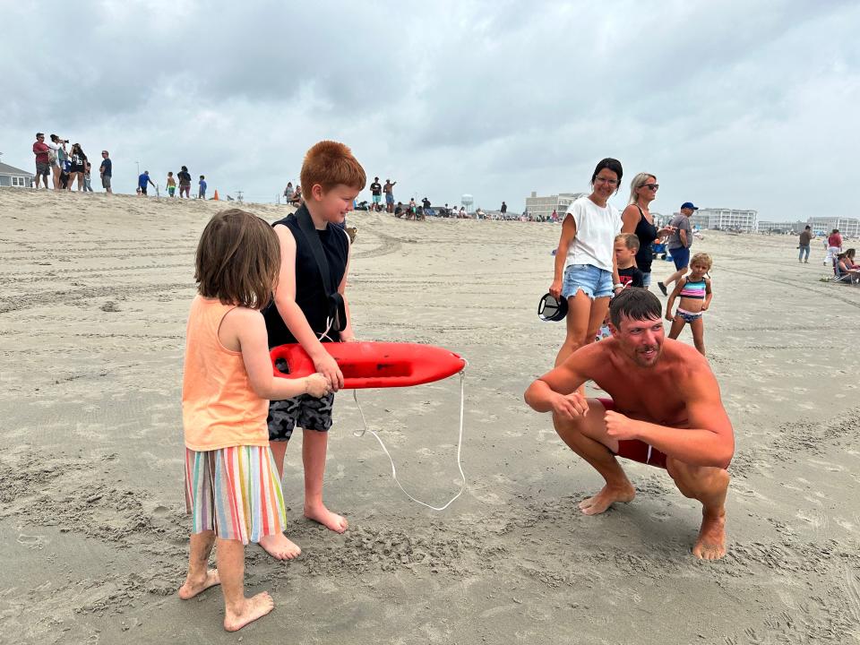 Lifeguard Keith Parent with two children visiting the beach for Water Safety Day held July 25.