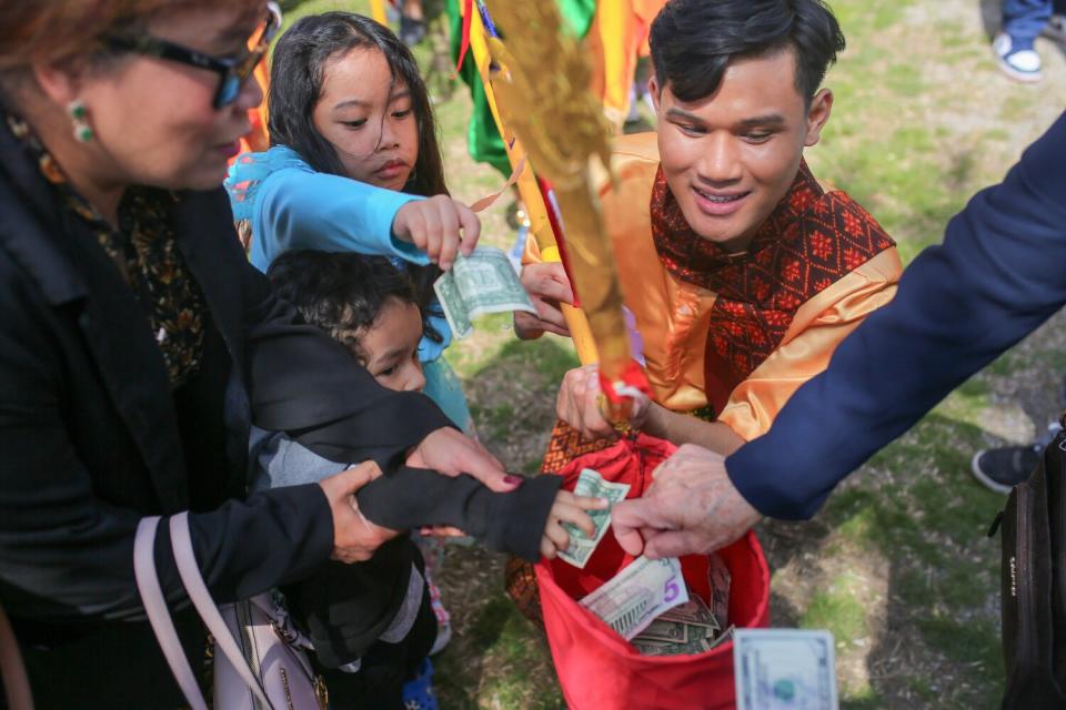 Audience members donate money to the Cambodian dance group at the Khmer New Year event.