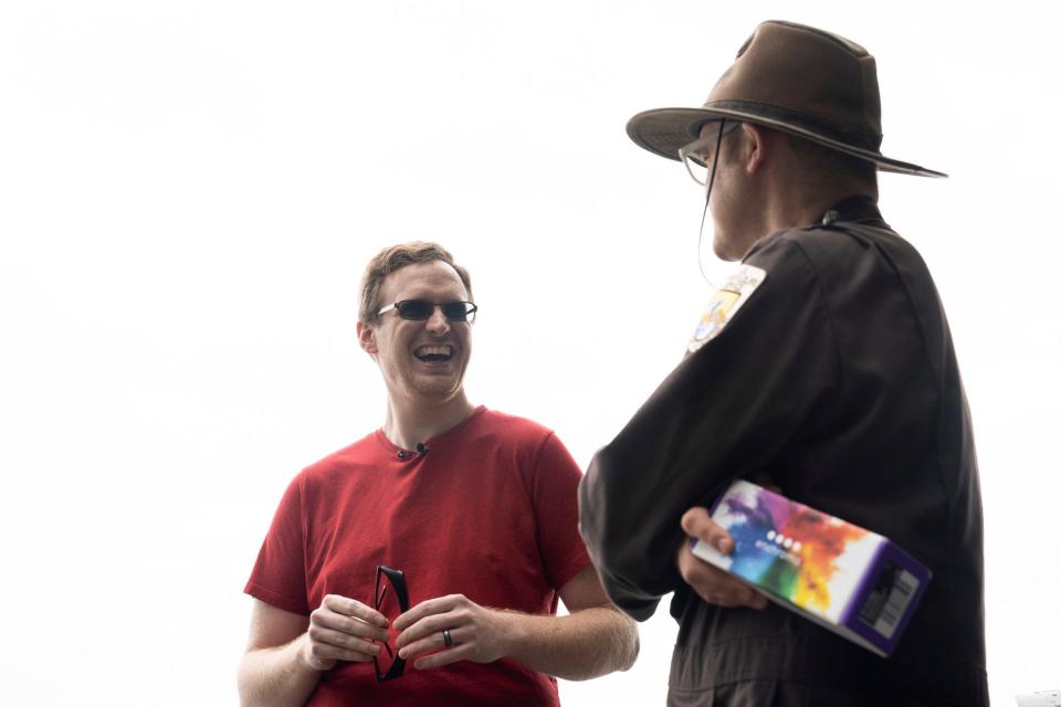 Tim Aepelbacher, 35 of Warren, shares a laugh with park ranger Tim Weston before Aepelbacher tries on the EnChroma glasses for the first time, enabling him to see in color at the Detroit River International Wildlife Center welcomed on Tuesday, June 13, 2023. The wildlife center welcomed two individuals with colorblindness to test out the EnChroma glasses for the first time, which enable colorblind people to see colors more clearly and vibrantly. Three EnChroma glasses will be available for visitors at the wildlife center, including one which allows prescription glasses underneath. Aepelbacher has a red-green color deficiency. At home, Aepelbacher's husband Jesse Capp doesn't allow Aepelbacher to cook meat because he typically can't tell the difference between red and brown.