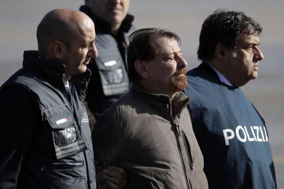 Italian fugitive Cesare Battisti arrives at Ciampino military airport, in Rome, Monday, Jan. 14, 2019. Battisti a left-wing Italian militant who was convicted of murder three decades ago is heading home to serve a life sentence, after his life as a celebrity fugitive came to an abrupt end with his arrest in Bolivia by a team of Interpol agents. (AP Photo/Gregorio Borgia)