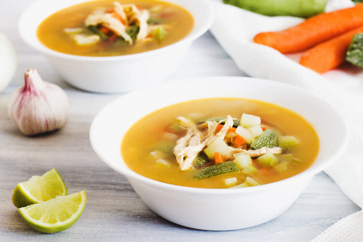 two bowl of caldo with lime on the side