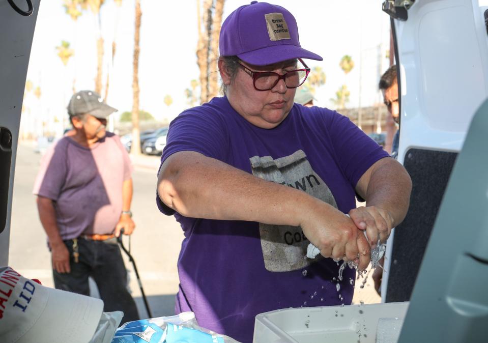 Maribel Padilla readies a cold washcloth and other items for unhoused people in Calexico, Calif., July 12, 2023.  Padilla is the founder of the Brown Bag Coalition which provides support to those in need in Imperial County. 