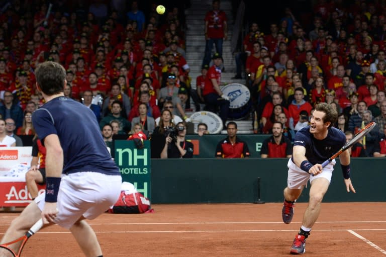 Britain's Andy Murray (R) returns the ball as his teammate and brother Jamie Murray looks on during their doubles match on the second day of the Davis Cup final between Belgium and Britain in Ghent on November 28, 2015