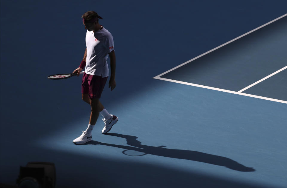 Switzerland's Roger Federer walks to receive serve from Tennys Sandgren of the U.S. during their quarterfinal match at the Australian Open tennis championship in Melbourne, Australia, Tuesday, Jan. 28, 2020. (AP Photo/Dita Alangkara)