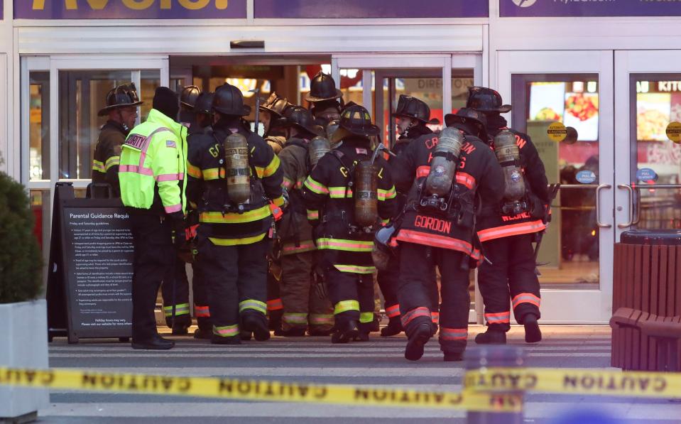 Firefighters enter the food court entrance at the Christiana Mall after a shooting Saturday evening, April 8, 2023.