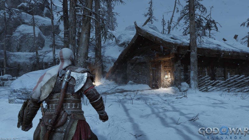 Kratos stands in the snow outside of his small log home. 