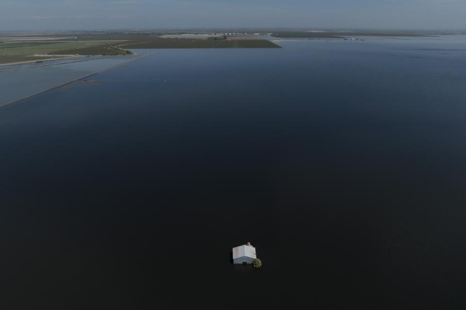 Farmland in the Tulare Lake Basin is submerged in water in Corcoran, Calif., Thursday, April 20, 2023, after more than a dozen atmospheric rivers dumped record-setting rain and snowfall. Residents in rural communities in the heart of the state are facing the prospect of being marooned by rising rivers or flooded out. (AP Photo/Jae C. Hong)