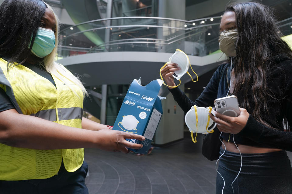 <p>MTA employee Shanita Hancle, left, hands out masks to commuters at the entrance to a subway station in New York, Thursday, June 8, 2023. Air pollution from Canadian wildfires are cloaking the northeastern U.S. for a second day. (AP Photo/Seth Wenig)</p> 