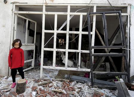 An little girl stand in front of her destroyed house in Kumanovo ,Macedonia May 12, 2015. REUTERS/Ognen Teofilovski