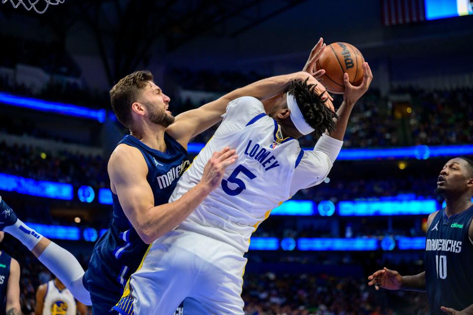 The Golden State Warriors' Kevon Looney (5) is fouled by the Dallas Mavericks' Maxi Kleber during the third quarter of Game 3 at American Airlines Center.