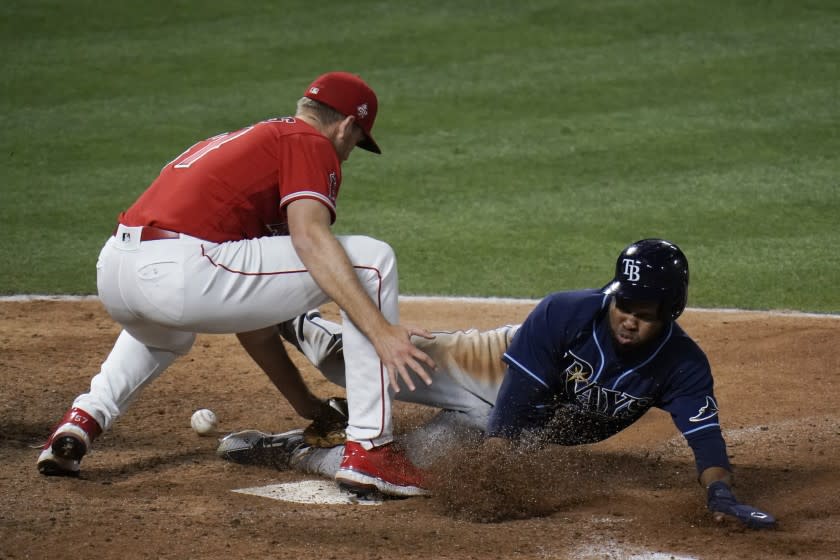 Tampa Bay Rays' Manuel Margot, right, steals home to score as Los Angeles Angels relief pitcher Aaron Slegers misses the throw during the eighth inning of a baseball game, Thursday, May 6, 2021, in Anaheim, Calif. (AP Photo/Jae C. Hong)