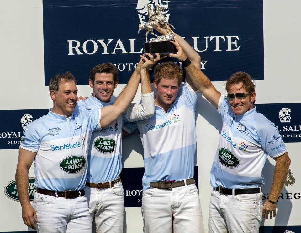 Britain's Prince Harry, center right, and teammates, from left, Michael Carrazza, Malcolm Borwick, and Marc Ganzi, pose with the trophy after winning the Sentebale Royal Salute Polo Cup charity match in Greenwich, Conn., Wednesday, May 15, 2013. (AP Photo/Craig Ruttle)