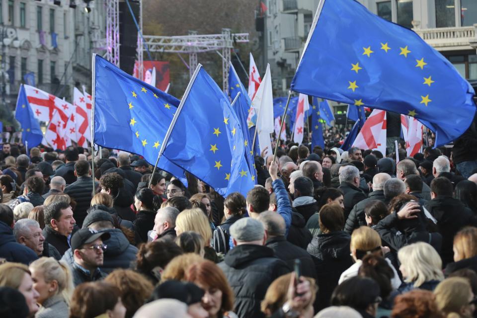 Georgians with EU and national flags gather to celebrate Georgia's EU candidacy at Liberty Square in Tbilisi, Georgia, on Friday, Dec. 15, 2023. Several thousand people attend a march in support of Georgia's EU candidacy. European Union flags waved across Georgia Friday after the European Council took a step forward along the long road towards granting Georgia and Moldova as EU membership. (AP Photo/Zurab Tsertsvadze)