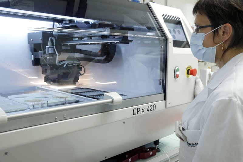 An employee of Swiss biotechnology company Molecular Partners controls a colony picker robot in a laboratory at the company's headquarters in Schlieren