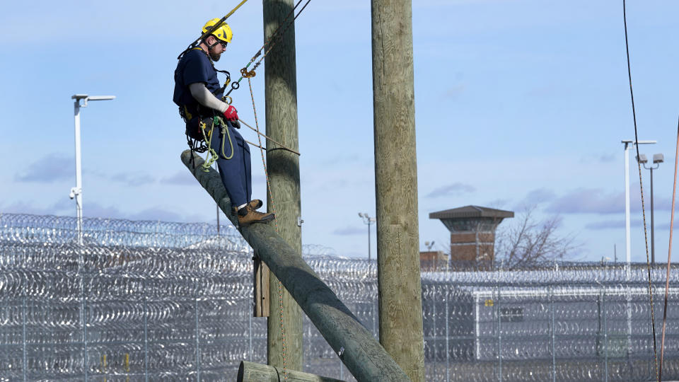 Prisoner Travis Stone works on climbing at the Parnall Correctional Facility's Vocational Village in Jackson, Mich., Thursday, Dec. 1, 2022. Stone is one of more than a dozen prisoners learning how to climb trees and trim branches around power lines as part of DTE Energy's $70 million plan to improve the utility's electric infrastructure. (AP Photo/Paul Sancya)
