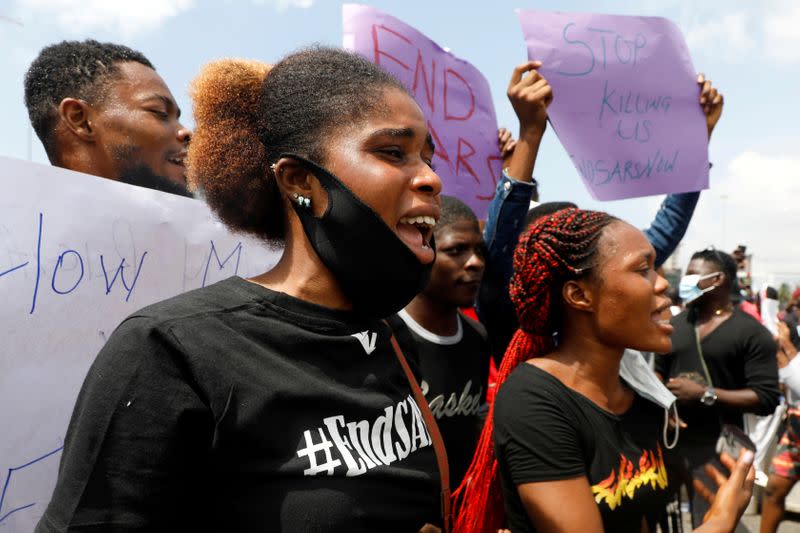 Demonstrators hold banners and shout slogans during a protest against alleged police brutality, in Lagos