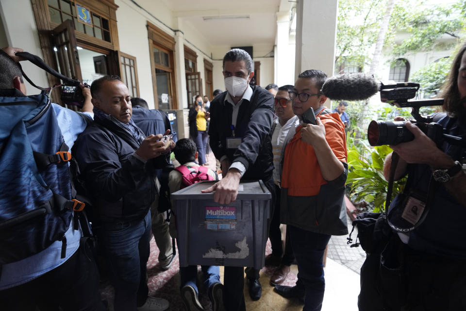 A member of Guatemala's attorney general's office carries a box with documents related to the Seed Movement political party as part of a raid on the headquarters of the country's electoral authority hours after it certified the results of the country's June 25 election in Guatemala City, Thursday, July 13, 2023. On Wednesday, the Attorney General's Office announced that a judge had suspended the legal status of the Seed Movement party, for alleged violations when it gathered the necessary signatures to form. Seed's candidate Bernardo Arévalo had been set to compete in a runoff election on Aug. 20. (AP Photo/Moises Castillo)