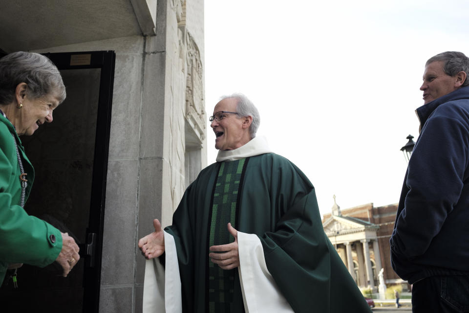 In this Sunday, Oct. 20, 2019 photo, Rev. William Tourigny, 66, center, pastor of St. Rose de Lima Parish, in Chicopee, Mass., greets parishioners following Mass in front of the Catholic church. When Tourigny was ordained in 1980, the Springfield diocese had more than 300 priests serving 136 parishes. Since then, the ranks of priests have shrunk by more than half and nearly 60 of the parishes have closed. For Tourigny, it's meant many more funerals to handle, including dozens related to drug overdoses and heavy drinking. (AP Photo/Steven Senne)