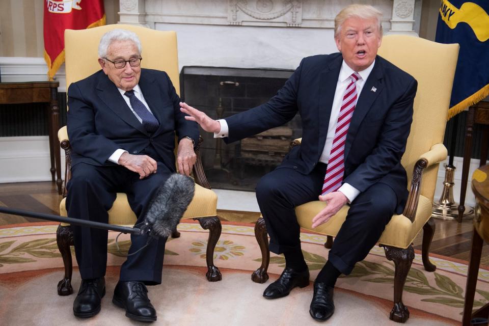 FILES) US President Donald Trump (R) speaks with former US Secretary of State Henry Kissinger during a meeting in the Oval Office in 2017. (AFP via Getty Images)