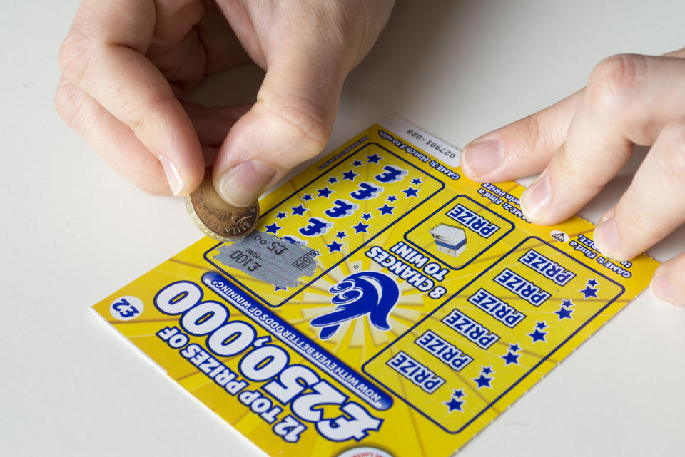 Scratching a National Lottery scratch card, England, UK. (Photo by: Alex Segre/UCG/Universal Images Group via Getty Images)