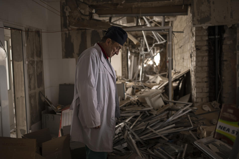 Ukrainian doctor Yurii Kuznetsov pauses in the destroyed surgery section of the hospital in Izium, Ukraine, Sunday, Feb. 18, 2023. Russian attacks have devastated Ukraine's health care system, raining down explosions upon hospitals and ambulances at a rate of nearly two a day for the past year, according to a study that attempted to document each strike. (AP Photo/Vadim Ghirda)