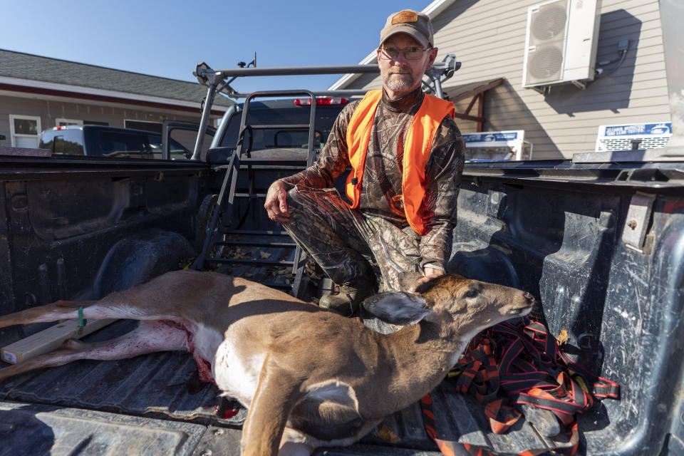 Hunter Andrew Moore of Windham, Maine, poses with his deer near a location that was recently searched during a manhunt for Robert Card, the suspect in this week's mass shootings, Saturday, Oct. 28, 2023, in Durham, Maine. Hunting had been temporarily banned in some communities during the search but following confirmation of Card's death, a public safety alert was issued that announced: "The search is over for Mr. Card. The caution is over. Hunting may resume." (AP Photo/Robert F. Bukaty)