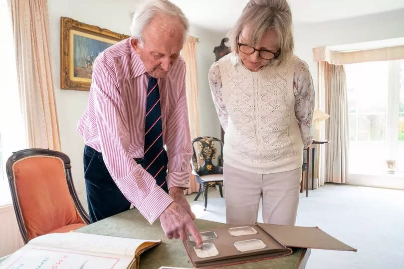 Sir Tom looks at notes and photographs from World War II with his daughter, Sarah Bartleet