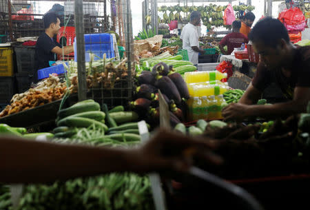 Shopkeepers arrange vegetables at a wet market in Malaysia's southern city of Johor Bahru April 26, 2017. REUTERS/Edgar Su