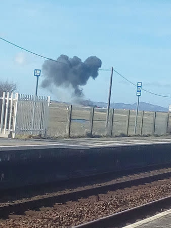 Smoke rises after a Royal Air Force Aerobatic Team, known as the Red Arrows, plane crashed in Valley, Anglesey, Wales, Britain March 20, 2018 in this image obtained from social media. Policing News Website Policehour/policehour.co.uk via REUTERS