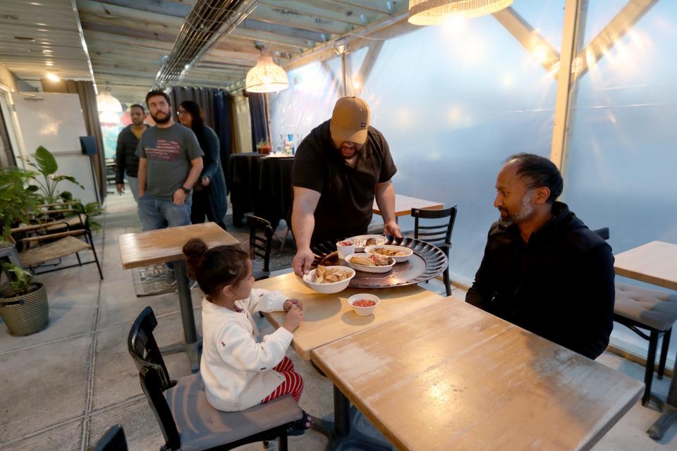 Owner and head chef Omar Anani in the kitchen of Saffron De Twah talks with Ravindra Kharmai and his daughter Maya, 3, about the menu Saturday, April 30, 2022. The restaurant specializes in modern Moroccan food.