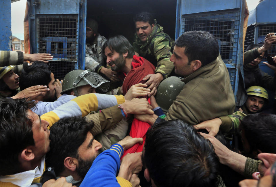 Indian policemen detain Jammu Kashmir Liberation Front (JKLF) chairman Yasin Malik, in red jacket, during a protest in Srinagar, India, Friday, March 7, 2014. Dozens of Muslim students from the disputed Indian territory of Kashmir were expelled from their university and briefly threatened with sedition charges because they cheered for the Pakistani cricket team during a televised match against archrival India, police said Thursday, while the Indian state's elected leader called for leniency. (AP Photo/Dar Yasin)