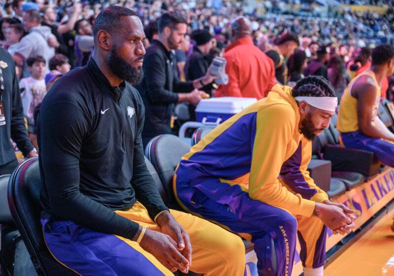 LOS ANGELES, CA - MARCH 18, 2024: Los Angeles Lakers forward LeBron James (23) and Los Angeles Lakers forward Anthony Davis (3) sit on the bench during introductions against the Atlanta Hawks at Crypto.com Arena on March 18, 2024 in Los Angeles, California.(Gina Ferazzi / Los Angeles Times)