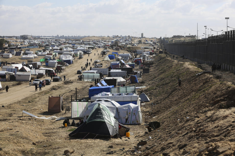 Palestinians displaced by the Israel air and ground offensive on the Gaza Striptake shelter near the border fence with Egypt in Rafah, Wednesday, Jan. 24, 2024. Israel and Egypt are engaged in an increasingly public spat over a narrow strip of land between Egypt and Gaza. That strip is the Philadelpi Corridor. The dispute puts Israel in a bind. If it stops its military offensive against Hamas without taking control of the southern Gaza city Rafah on the border with Egypt, it falls short on its top war goal of crushing the Islamic militants. If its military pushes south to the border, it risks undermining its peace deal with Egypt and likely upsetting its closest ally, the United States. The Egypt-Israel peace deal has been a pillar of stability in a turbulent Middle East.(AP Photo/Hatem Ali)