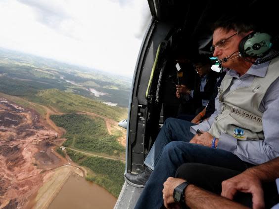 President Jair Bolsonaro surveys area buried by mud in Brumadinho (AP)