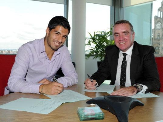 Luis Suarez signs a new Liverpool contract with Managing Director Ian Ayre in 2012 (Getty)