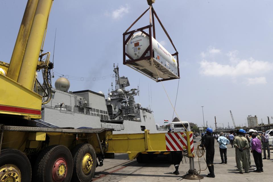 FILE - In this May 10, 2021, file photo, Liquid Medical Oxygen (LMO) cryogenic containers are unloaded from Indian naval vessel INS Trikand that arrived from Hamad Port, Qatar at Naval Dockyard In Mumbai, India. A dip in the number of coronavirus cases in Mumbai is offering a glimmer of hope for India, which is suffering through a surge of infections. But experts say the crisis is far from over in the country of nearly 1.4 billion people, with hospitals still overwhelmed and officials struggling with short supplies of oxygen and beds. (AP Photo/Rajanish Kakade, File)