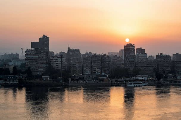 PHOTO: The sun rises behind the skyline of Egypt's capital Cairo and its Nile river island of Manial, Nov. 3, 2022. (Mohammed Abed/AFP via Getty Images)