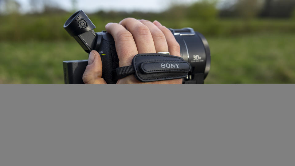 The Sony FDR-AX53 camcorder in a photographer's hand