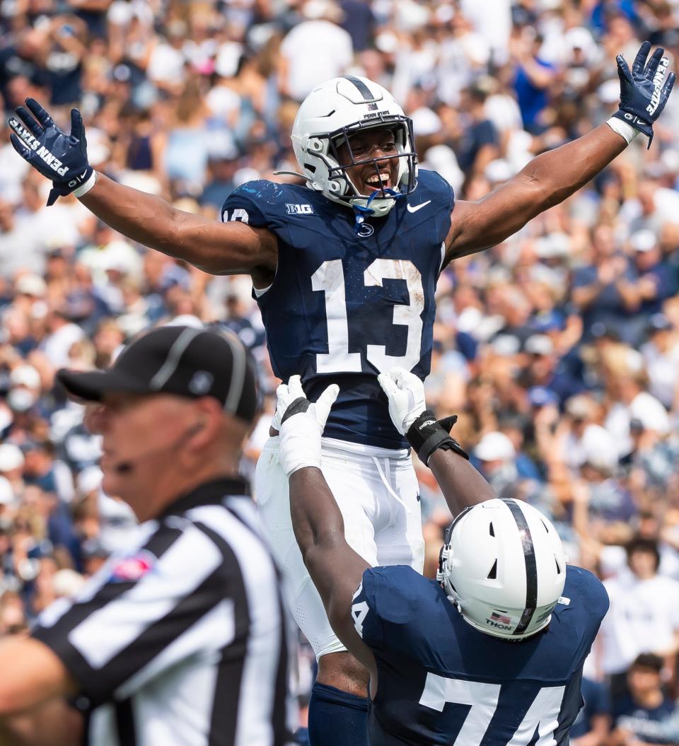 Penn State running back Kaytron Allen (13) celebrates his first touchdown of the season with offensive lineman Olu Fashanu (74) during the first quarter of an NCAA football game against Delaware Saturday, Sept. 9, 2023, in State College, Pa.