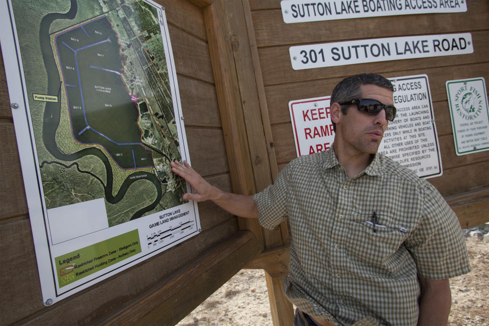Cape Fear Riverkeeper Kemp Burdette shows the location of the L.V. Sutton Complex operated by Duke Energy and it's proximity to Sutton Lake and the Cape Fear River at a map located at the lake's landing in Wilmington, N.C., Wednesday, Feb. 19, 2014. In the wake of Duke Energy’s massive coal ash spill in Eden, people in the tight-knit Flemington community are paying close attention to the environmental disaster unfolding 200 miles to the northwest along the Dan River. (AP Photo/Randall Hill)
