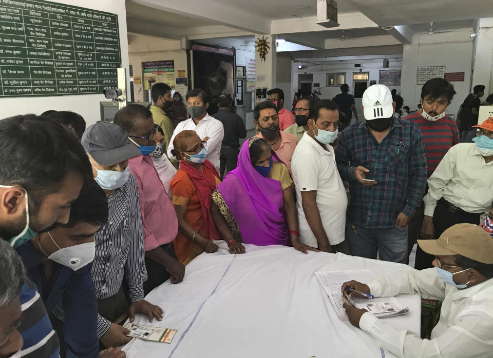 People wait to register themselves to receive the vaccine for COVID-19 at Railway hospital in Prayagraj, India, Saturday, April 10, 2021. India has a seven-day rolling average of more than 100,000 cases per day and has reported 13 million virus cases since the pandemic began, the third-highest total after the United States and Brazil. (AP Photo/Rajesh Kumar Singh)