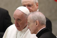 Pope Francis shares a word with Monsignor Luis Maria Rodrigo Ewart as he arrives in the Paul VI Hall at the Vatican for his weekly general audience, Wednesday, Oct. 28, 2020. A Vatican official who is a key member of Francis' COVID-19 response commission, the Rev. Augusto Zampini, acknowledged Tuesday that at age 83 and with part of his lung removed after an illness in his youth, Francis would be at high risk for complications if he were to become infected. Zampini said he hoped Francis would don a mask at least when he greeted people during the general audience. "We are working on that," he said. (AP Photo/Alessandra Tarantino)