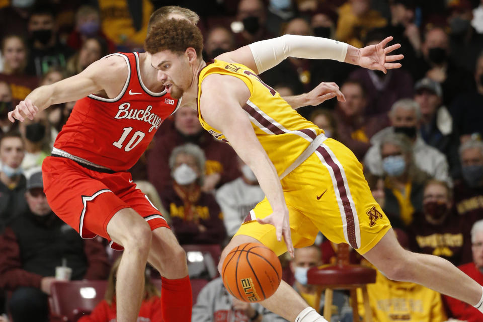 Minnesota forward Jamison Battle, right, drives past Ohio State forward Justin Ahrens (10) in the second half of an NCAA college basketball game Thursday, Jan. 27, 2022, in Minneapolis. (AP Photo/Bruce Kluckhohn)
