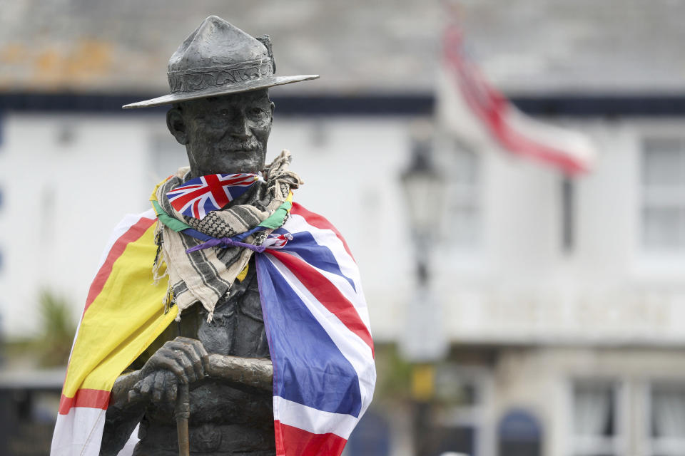 A Dorset flag, left, and a British flag wrap a statue of Robert Baden-Powell on Poole Quay in Dorset, Britain, Friday June 12, 2020. Officials plan to remove a statue of the founder of the Scouts movement from the quayside in Poole, southern England, out of concern it may be a target for protests ignited by the death of George Floyd, who died after he was restrained by Minneapolis police on May 25. (Andrew Matthews/PA via AP)