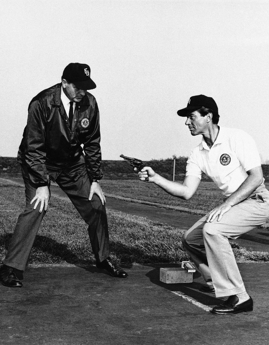 FILE - During an actual training session at the FBI Academy, TV star Efrem Zimbalist, Jr., right, perfects his pistol firing technique under the watchful eyes of an unidentified FBI instructor, in this May 21, 1965 file photo taken in Quantico, Va. Zimbalist, the son of famous musicians who gained television stardom in the 1950s-60s hit "77 Sunset Strip" and later "The FBI," died Friday at his ranch in Solvang, Calif., at age 95. (AP Photo, File)