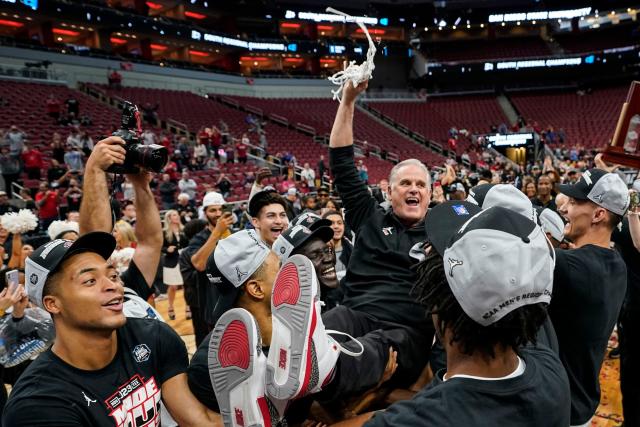 San Diego State coach Brian Dutcher holds the remains of the net after the Aztecs defeated Creighton to advance to the Final Four of the NCAA men's tournament.