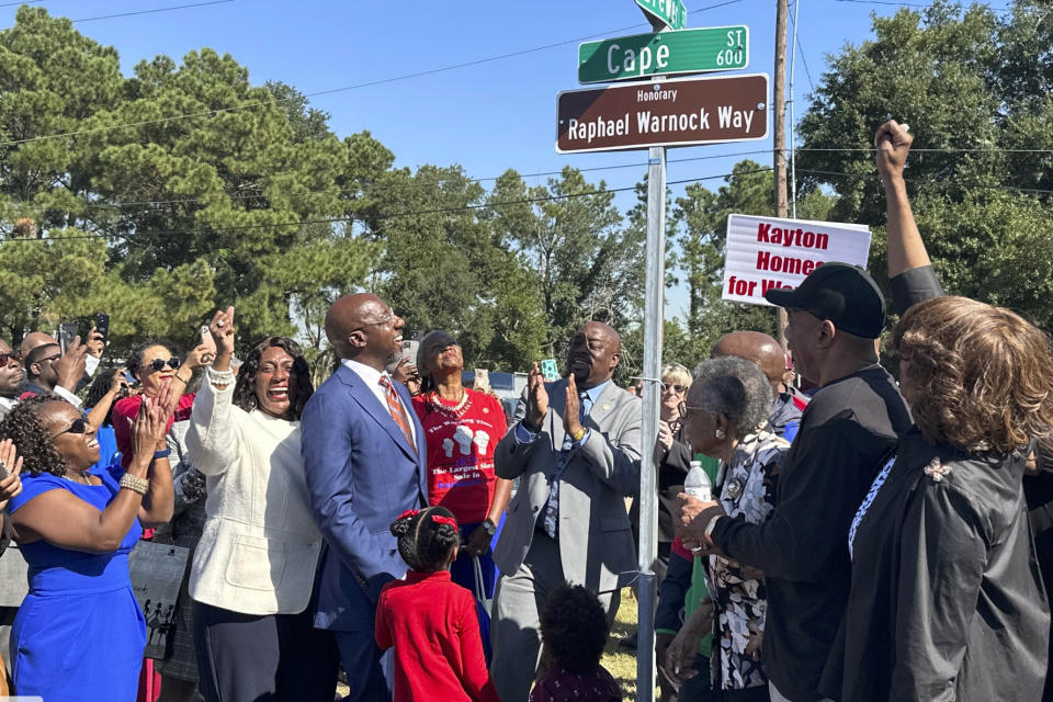 U.S. Sen. Raphael Warnock, D-Ga., views a street sign during a ceremony naming a street in Warnock's honor in his hometown of Savannah, Ga., on Thursday, Oct. 6, 2022. Warnock, a freshman Democrat, is up for reelection in November in a pivotal race against Republican and former football star Herschel Walker. (AP Photo/Lewis M. Levine)