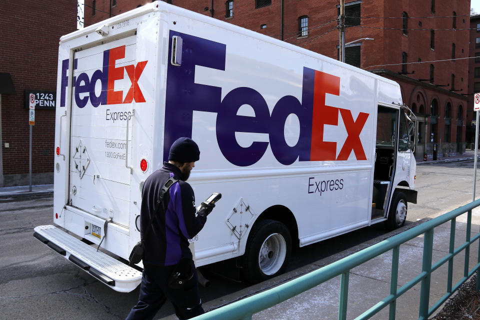 FILE – In this Friday, March 17, 2017, file photo, a FedEx driver returns to his truck in downtown Pittsburgh. FedEx says it will give wage increases, bonuses and make a voluntary $1.5 billion contribution to its pension plan following recent tax reform legislation. The company will also invest $1.5 billion to expand its FedEx Express facility in Indianapolis over the next seven years. (AP Photo/Gene J. Puskar, File)