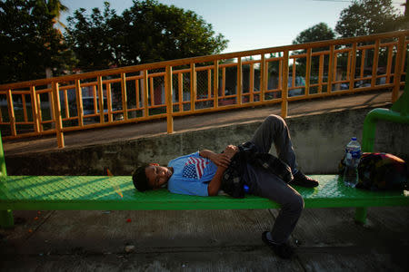 Migrant Jonathan Dias, 14, from Honduras, rests while waiting for his father, during their journey towards the United States, in the outskirts of Ciudad Hidalgo, Mexico, January 18, 2019. REUTERS/Alexandre Meneghini