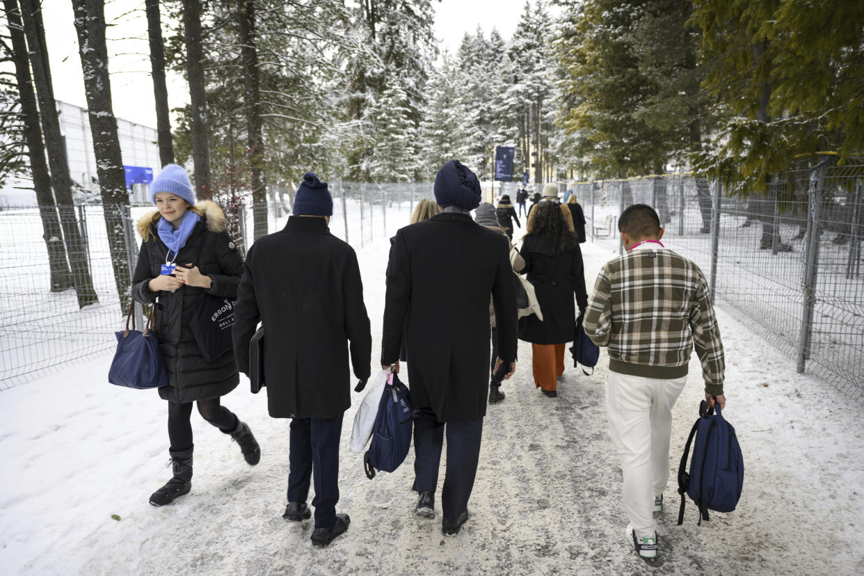 Participants walk on a snow covered path outside the Congress Centre during the 53rd annual meeting of the World Economic Forum, WEF, in Davos, Switzerland, Monday, Jan 16, 2023. The meeting brings together entrepreneurs, scientists, corporate and political leaders in Davos under the topic "Cooperation in a Fragmented World" from 16 to 20 January. (Laurent Gillieron/Keystone via AP)